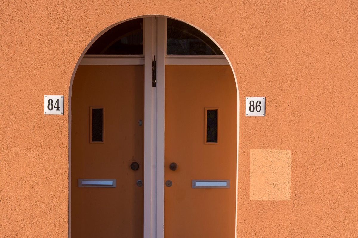 An arched double doorway in an orange plastered wall