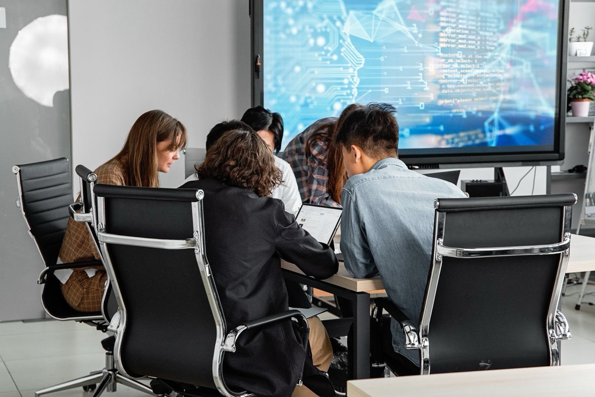 A meeting around a conference table, seen from behind